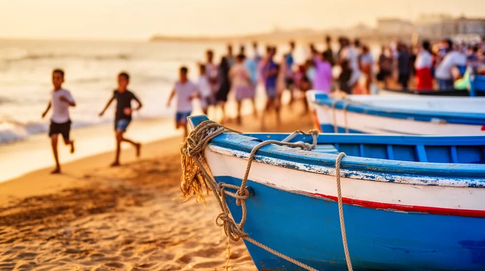 Une plage méditerranéenne en octobre, barques de pêche tirées sur le sable et familles au bord de l’eau